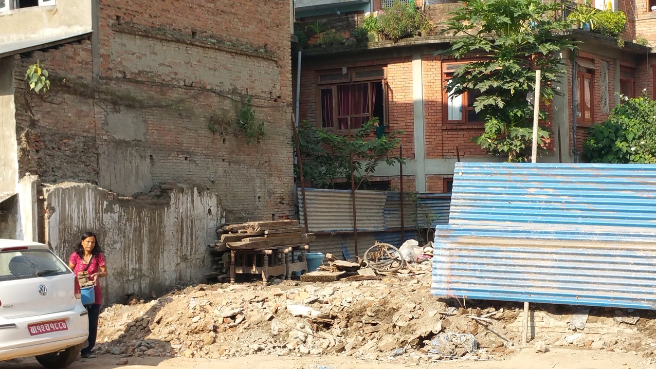 Aus dem Schutt eines eingestürzten Hauses sammelt diese Frau noch brauchbare Steine und setzt diese zur Reparatur ihres Hauses auf der andern Straßenseite ein.
