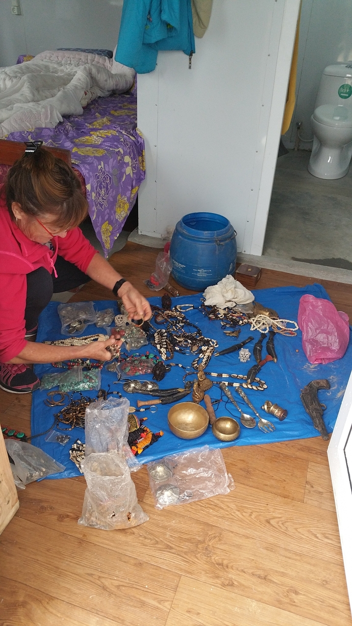 Die Reste von Dolmas Schmuck- und Souvenierverkauf, die 2015 aus den Ruinen geborgen werden konnten, werden fachgerecht inspiziert und für den Verkauf auf einem Schulbasar in Ettlingen aussortiert. Wegen der langen Lagerung in feuchter Umgebung ist nicht mehr alles beutzbar.
